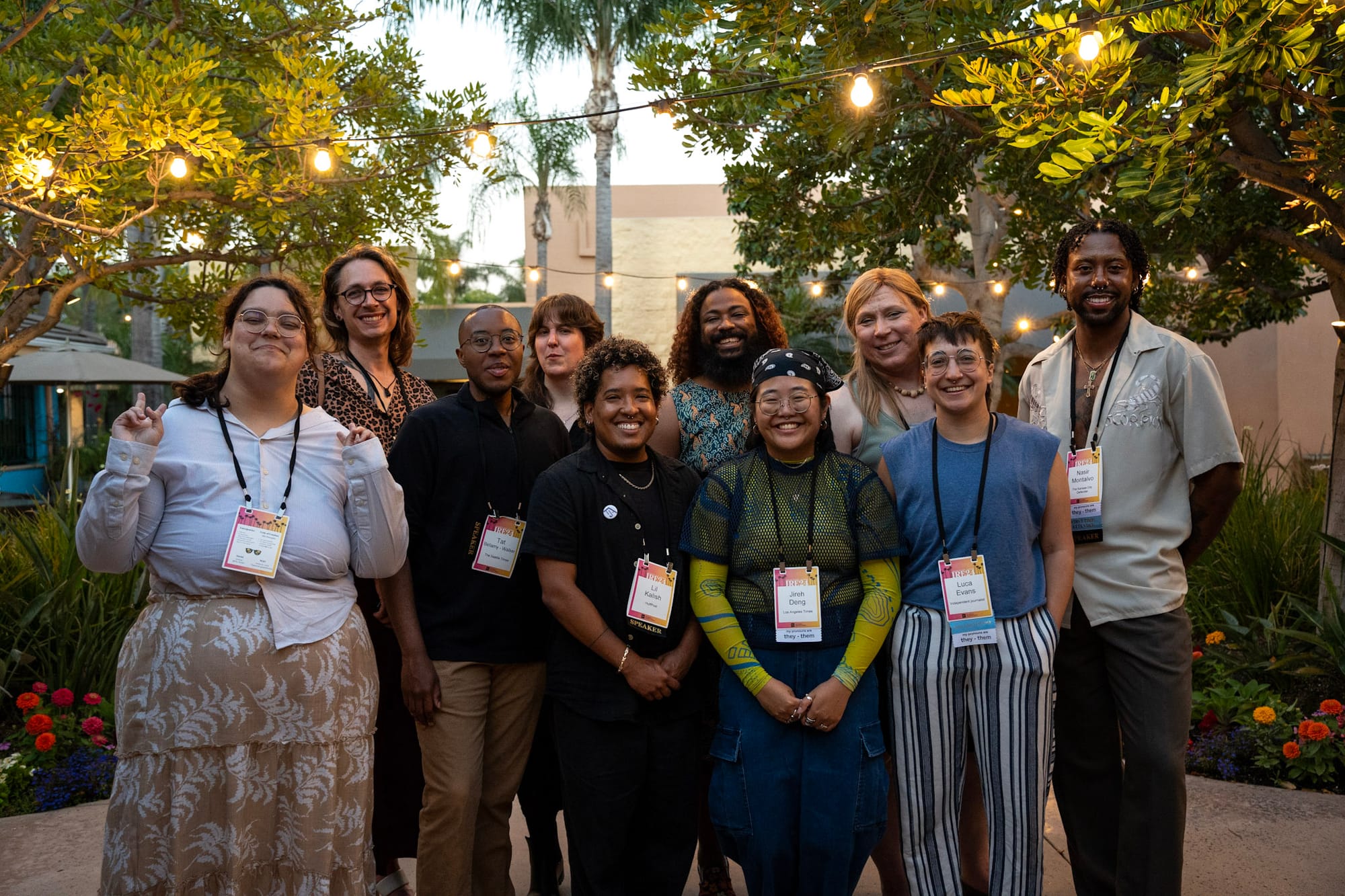 A photo of smiling gender-expansive journalists on an outdoor patio.